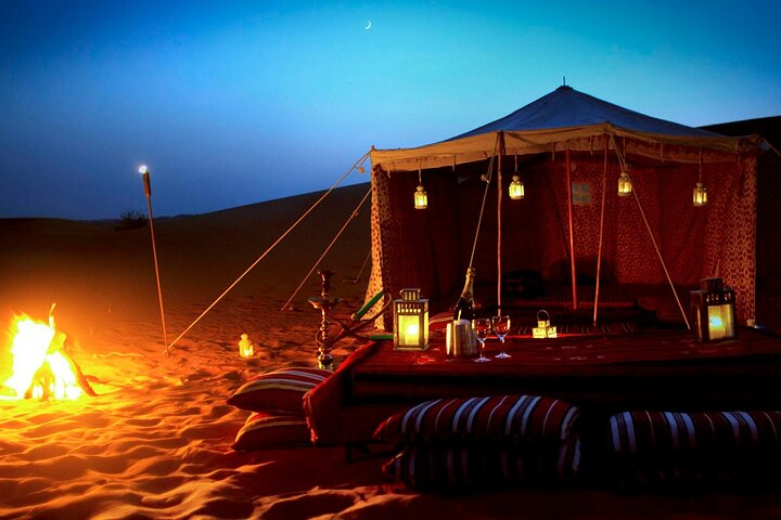Experience the charm of a desert night complete with a cozy camp flickering lanterns and the aroma of Middle Eastern cuisine perfect for star-gazing and unwinding under the vast sky.